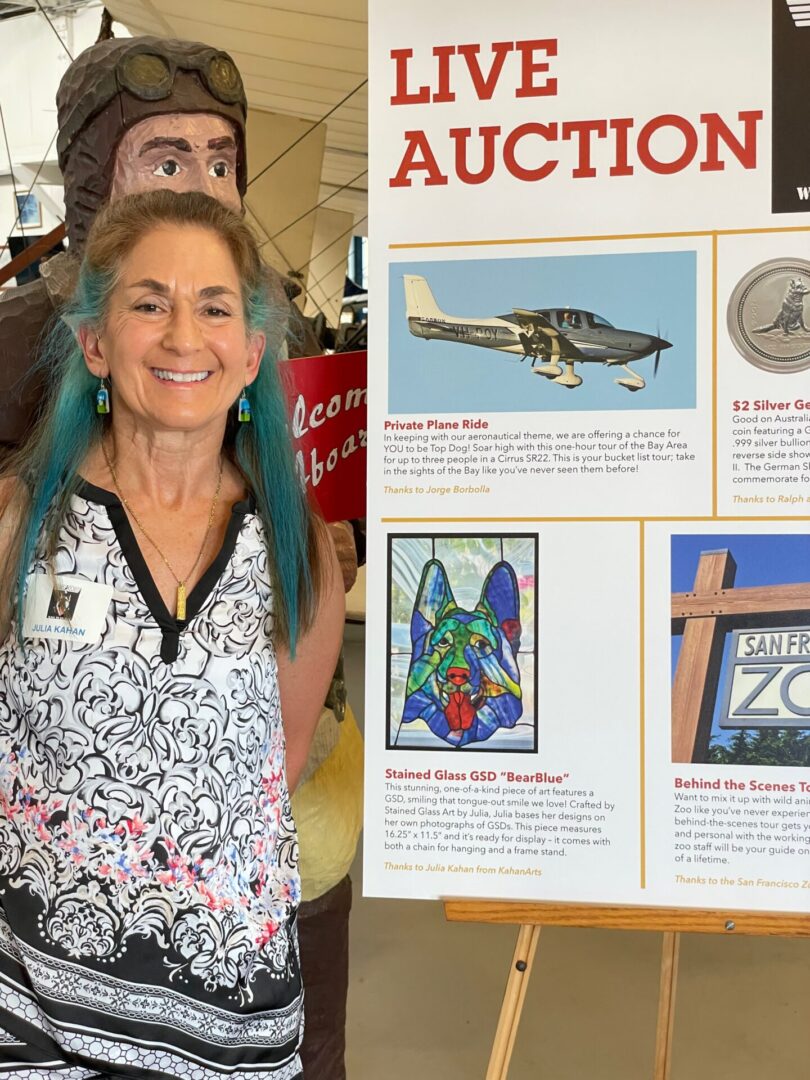 A woman standing next to an auction sign.