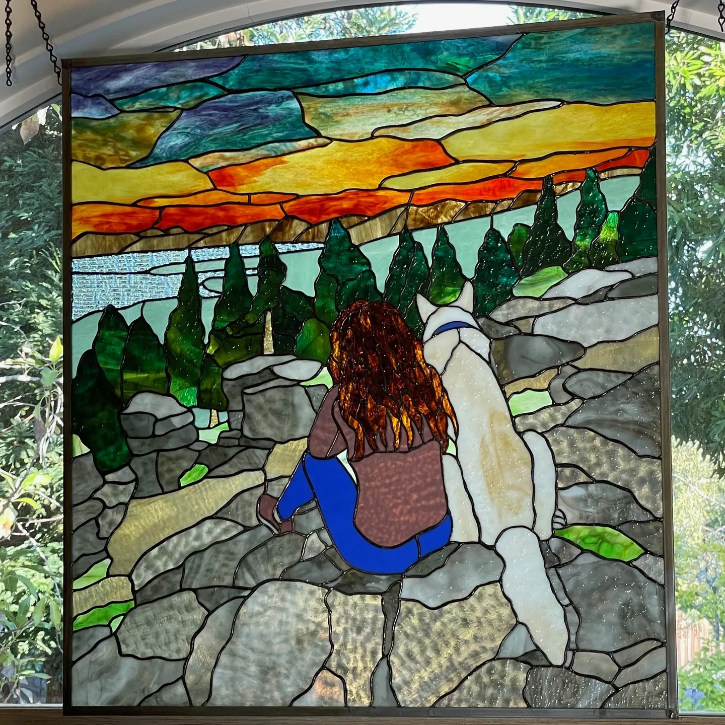 A stained glass window of a woman and her dog.